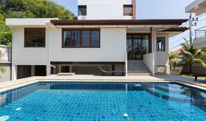 A modern two-story house with a swimming pool.