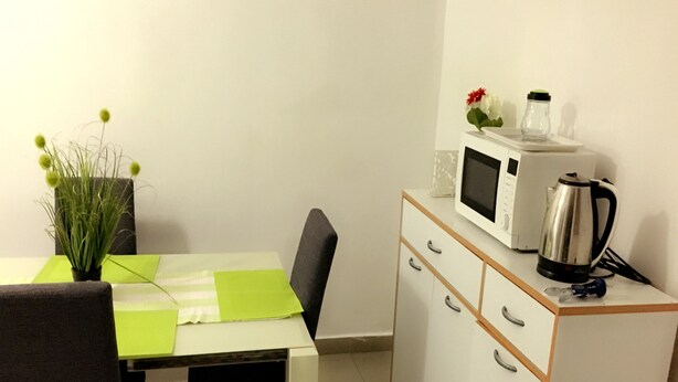 A small kitchenette with a microwave, kettle, and a cabinet with drawers. - Résidence Bimbois (Abidjan)