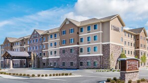 Een Staybridge Suites hotel met een stenen gevel, meerdere verdiepingen en een overdekte ingang.