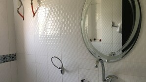 Een badkamer met een witte wastafel, een ronde spiegel en een toilet.