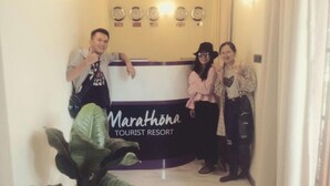A reception desk at Marathon Tourist Resort with clocks and flags on the wall. - Marathona Tourist Resort - Anuradhapura (Anuradhapura)