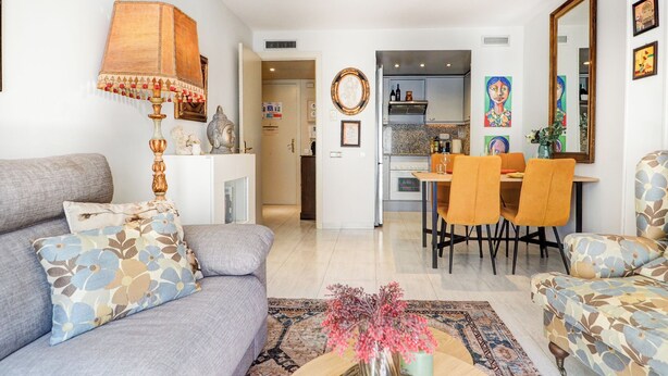 Un salon moderne comprenant un canapé, une table basse et un coin repas avec des chaises.