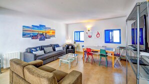 Un salon moderne comprenant un canapé, une table basse et un coin repas avec des chaises et une table.