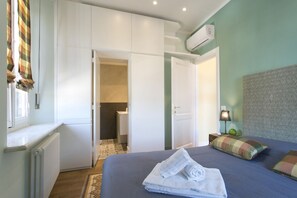 Una camera da letto con un letto, un termosifone, un armadio e un condizionatore d'aria.