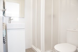 Une salle de bain équipée d’une douche, de toilettes et d’un lavabo.