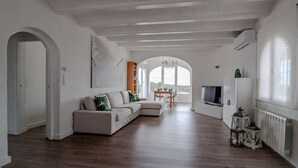 Un salon spacieux avec un canapé d’angle, une table à manger et un téléviseur.