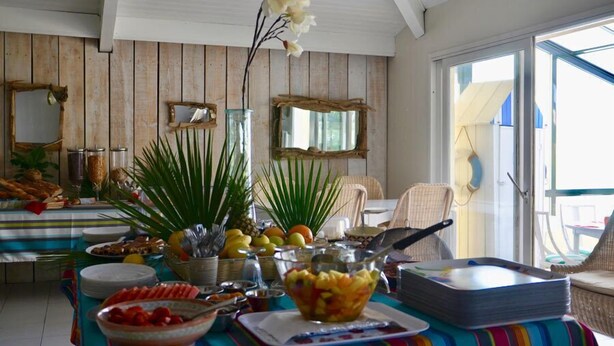 Un comedor con una barra de buffet, que incluye frutas, verduras y diversos platos.