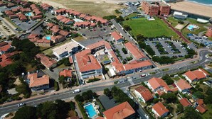 Vista aérea de una zona residencial costera con casas, una playa y una carretera.