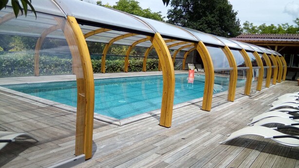 A pool area with a wooden deck and a covered seating area. - Le Domaine de Pecany (Le Buisson-de-Cadouin)