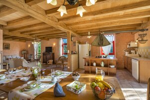 Interior rústico de madeira com área de refeições, cozinha e espaço para sentar.