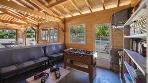 A cozy indoor space with a foosball table, a sofa, and a television. - Le Domaine de Pecany (Le Buisson-de-Cadouin)