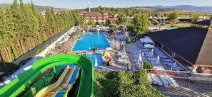 A resort with a swimming pool, lounge chairs, and a water slide. - Mertur Hotel (Ciftlikkoy)