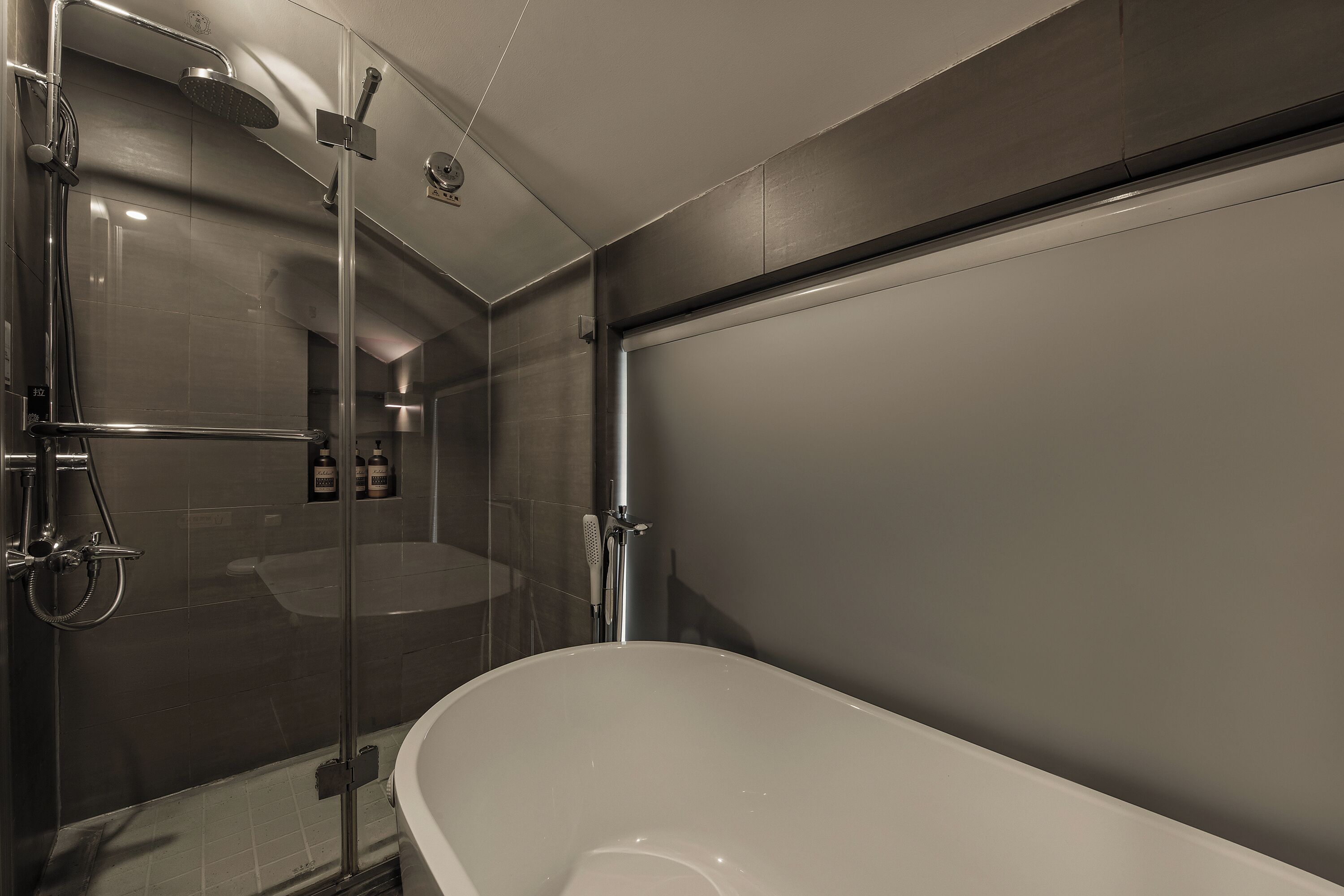 A modern bathroom with a glass-enclosed shower, a freestanding bathtub, and a wall-mounted toilet.