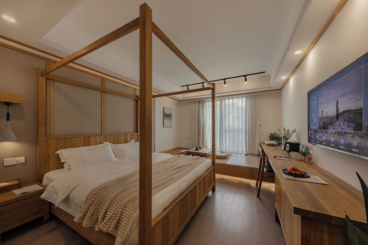 Ein modernes Schlafzimmer mit einem Himmelbett, einem Holztisch und einem Stadtbild.