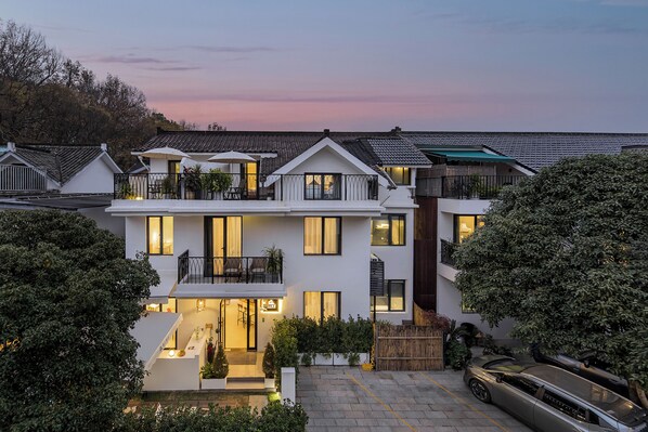 A modern two-story house with a balcony, a driveway, and a parked car. - Hangzhou West Lake Yueshang Yunshe Boutique Homestay (Hangzhou)