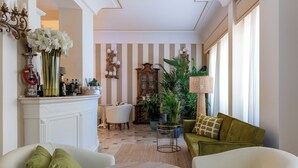 Una habitación luminosa con chimenea, una mesa de comedor y un sofá.