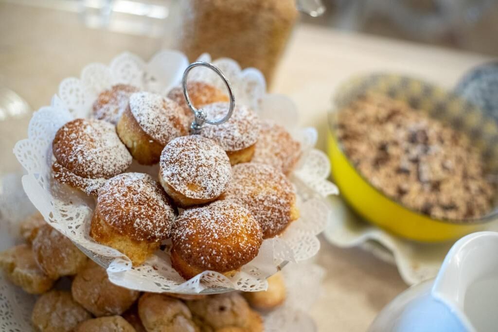 Un piatto di pasticcini cosparsi di zucchero a velo, con una ciambella.