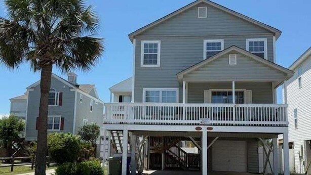 A two-story house with a covered porch and a garage.