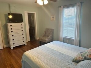 A bedroom with a bed, a dresser, a chair, and a window with blinds. - Pierview 5 Bedroom Home by RedAwning (Surfside Beach)