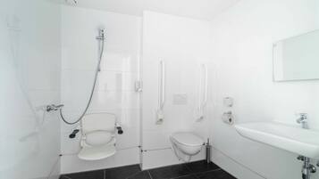 A modern bathroom with a shower, toilet, bidet, and sink.