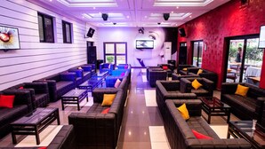 A modern lounge area with multiple seating options, including sofas and armchairs, arranged in a spacious layout.
