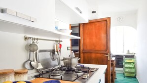 A kitchen with a stove, pots, and a wooden cutting board with lemons.