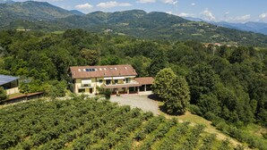 Una casa de dos pisos con techo inclinado, paneles solares y un balcón.