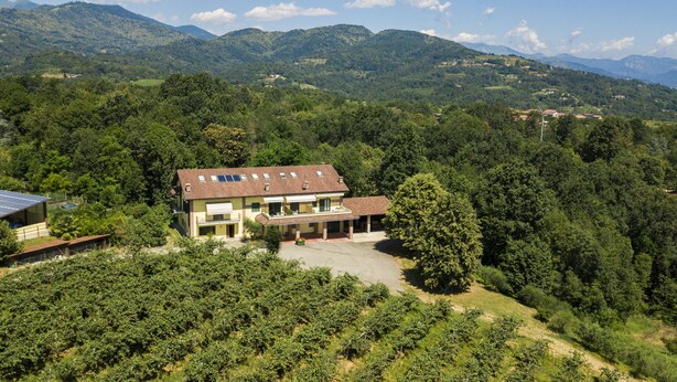 A two-story house with a sloped roof, solar panels, and a balcony.