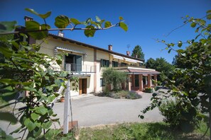 A two-story house with a paved driveway and a small garden area. - Agriturismo Turina by Connexion (Bricherasio)