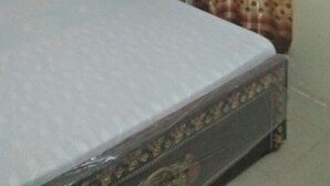 Una camera da letto con un letto, un comodino e una tenda.