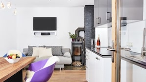 Une cuisine moderne avec des armoires blanches, un comptoir noir et une cuisinière intégrée.