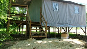 A rustic wooden structure with a covered porch and a staircase leading to a platform. - Camping Les Vignes (Puy-l'Eveque)