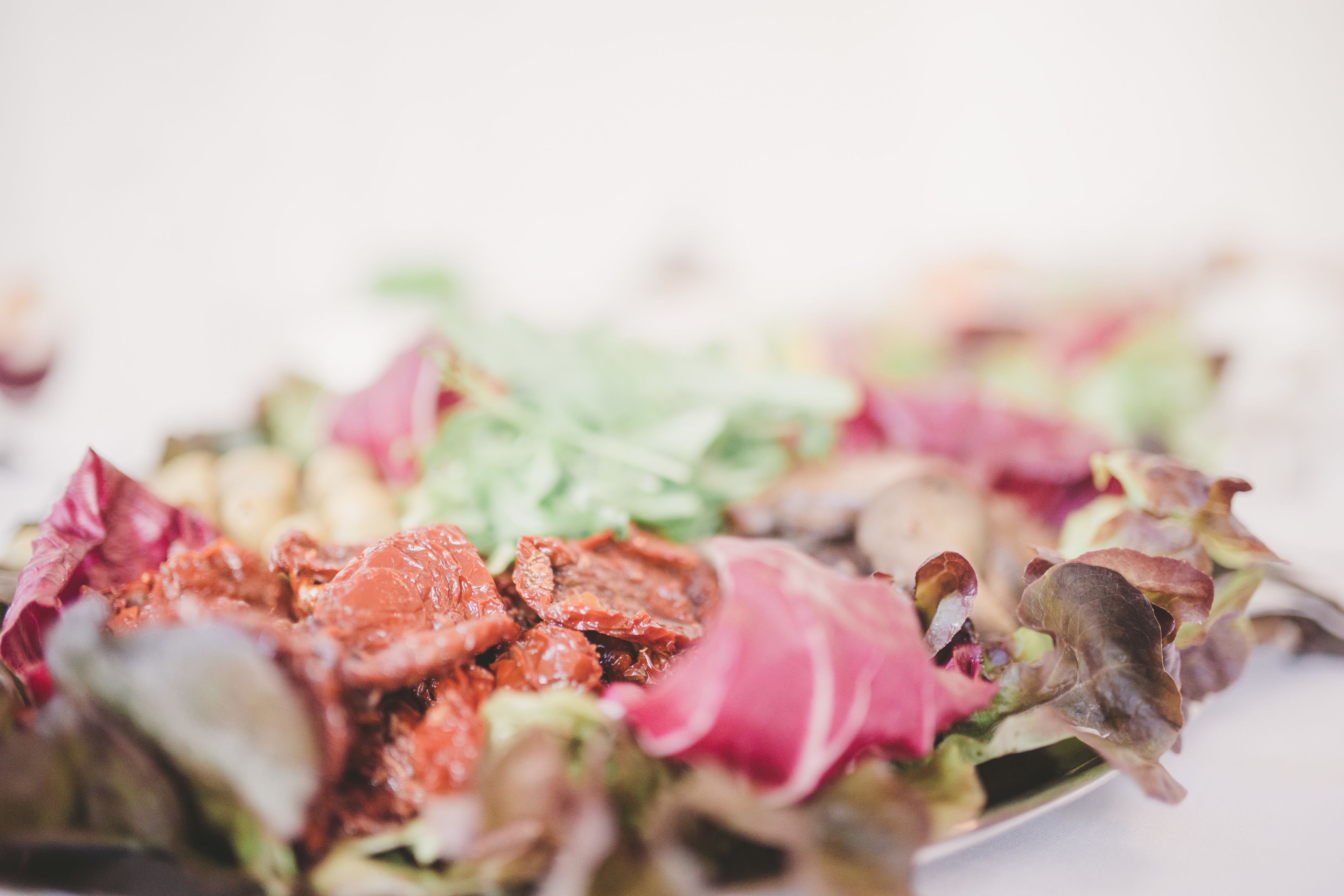 Close-up van een salade met verschillende groene bladeren en mogelijk krab.