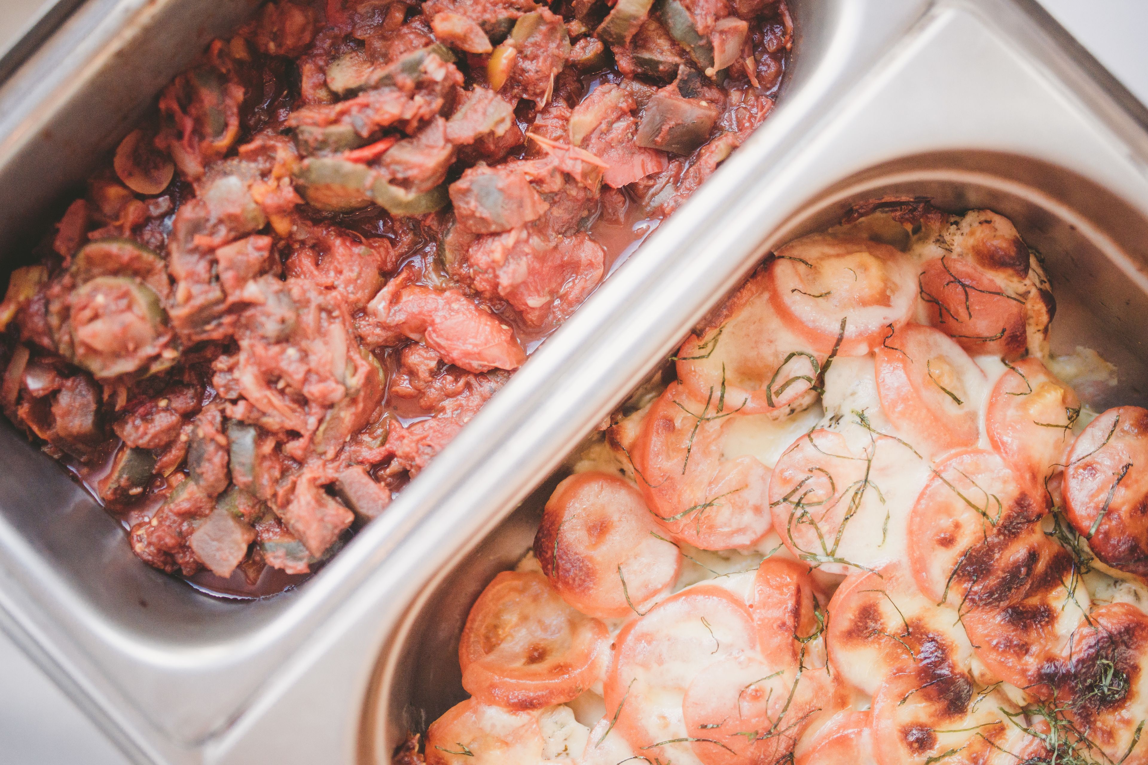 Zwei Gerichte, eines mit Kartoffelscheiben und Kräutern, das andere mit einem Gericht aus Fleisch.