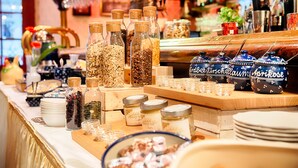 A bar area with various jars of snacks and condiments, a selection of glasses, and a display of blue ceramic containers.