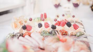 A buffet with various food items including fruits and cheeses.