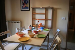 A dining table with various dishes and a coffee pot, surrounded by chairs. - Casa vacanze Cucciolo (Rimini)
