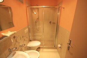 A bathroom with a glass-enclosed shower, a toilet, and a sink. - Casa vacanze Cucciolo (Rimini)