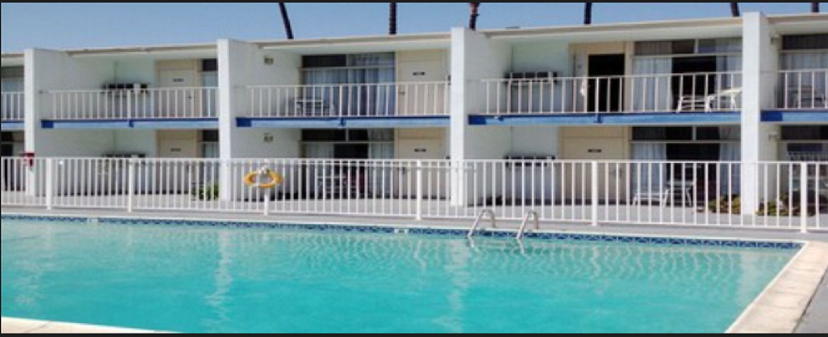 A multi-story hotel with a swimming pool.