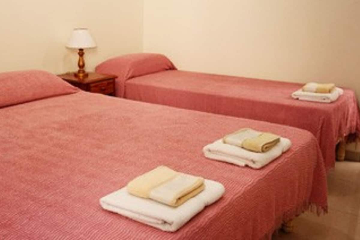 Tabla de planchar con plancha y ropa de cama