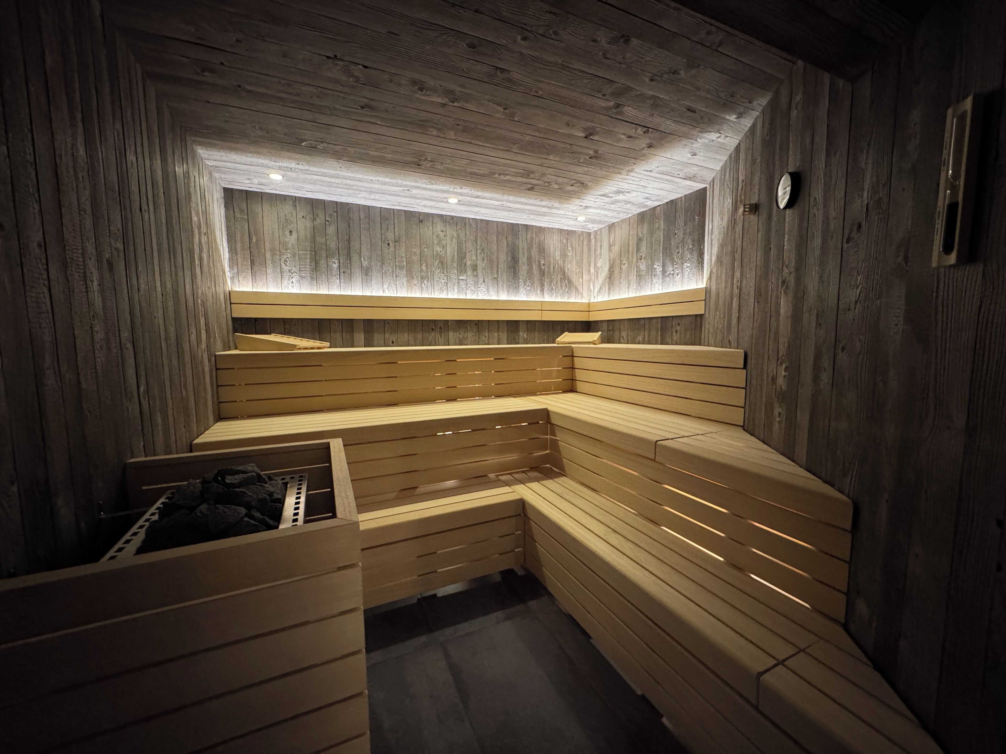 Una sauna con bancos de madera y techo inclinado.