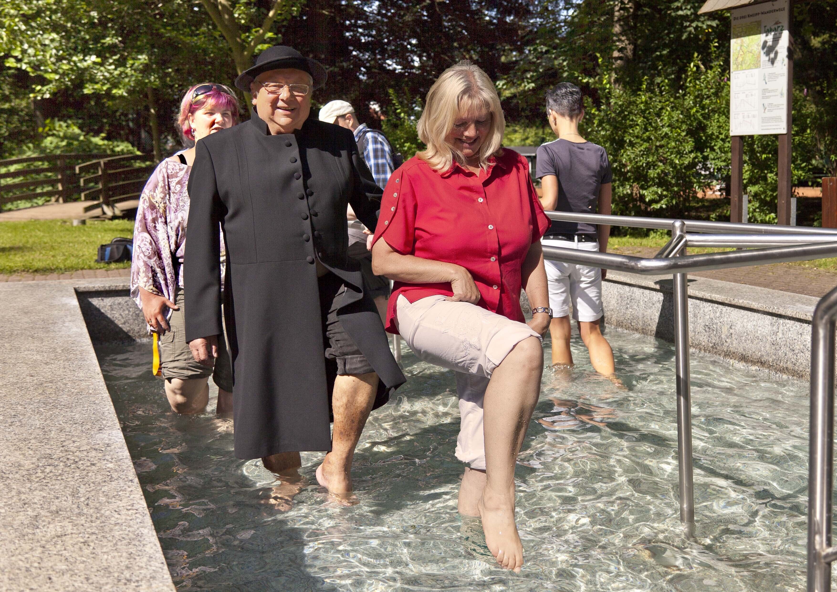 Ein öffentlicher Badebereich mit klarem Wasser, Metallgeländern und einem Schild.