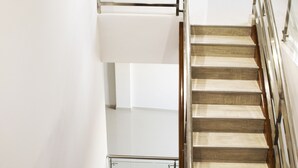 A multi-level interior with a staircase, metal railings, and a framed artwork on the wall. - Sea Colors Hotel (San Andrés)