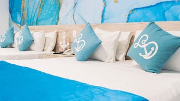 A hotel room with a large abstract painting on the wall, a wooden headboard, and multiple pillows with a logo.