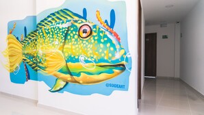 A hallway with a large mural of a fish on the wall. - Sea Colors Hotel (San Andrés)