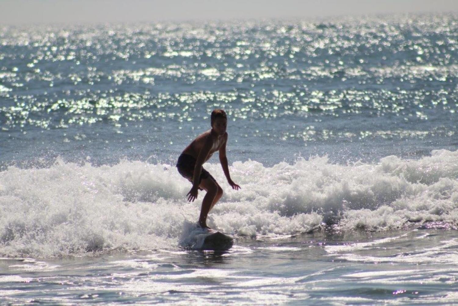 A person surfing on a wave in the ocean.