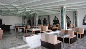 A spacious indoor area with multiple seating arrangements, including sofas and tables, and a distinctive ceiling design. - Palmyra Holiday Resort & Spa (Monastir)