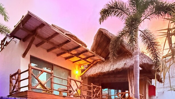 A resort with a pool, a thatched-roof structure, and palm trees. - A&V Hotel Boutique (Coyuca de Benitez)