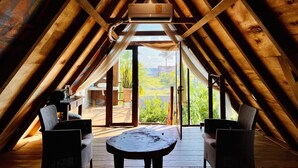 An attic room with wooden beams, a ceiling fan, and a view of the outdoors. - A&V Hotel Boutique (Coyuca de Benitez)