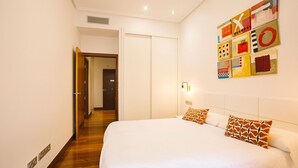 Una habitación de hotel con una cama grande, un armario y un pasillo que conduce a otra habitación.